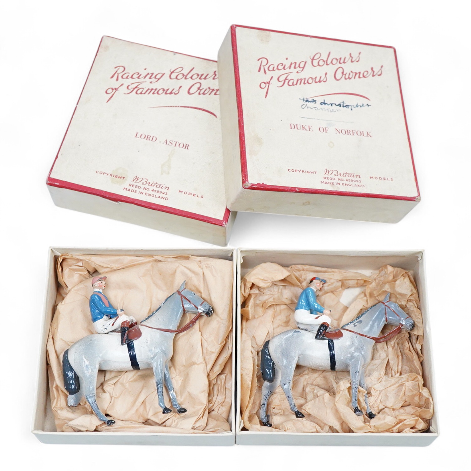Two boxed Britains Racing Colours of Famous Owners series lead mounted figures; Lord Astor - rider in blue jersey with a pink sash on a grey horse (one leg broken and missing), and. the Duke of Norfolk - rider in blue je
